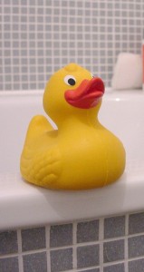 Gelbe Badeente auf der Badewanne.